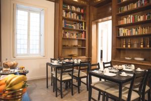 巴里Fourooms - Bari Sparano的用餐室配有桌椅和书架