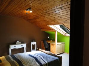 PorcheresseChambres d'hôtes des Ardennes的一间卧室配有一张床、一张书桌和一个窗户。