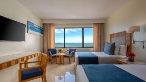 坎昆Park Royal Beach Cancun - All Inclusive的酒店客房设有两张床和一台平面电视。