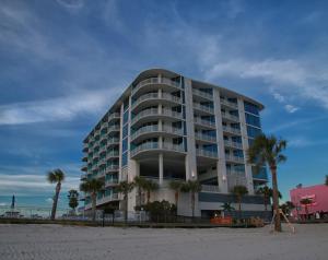 比洛克西南滩比洛克西酒店及套房的海滩上的一座建筑,前面有棕榈树