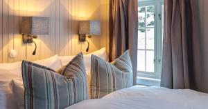 NussfjordNusfjord Arctic Resort的卧室配有带枕头的床铺和窗户。