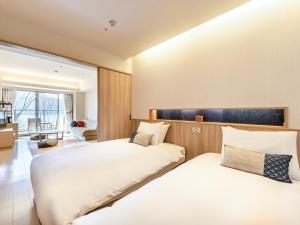 箱根箱根芦之湖花织旅馆(Hakone Ashinoko Hanaori)的带大窗户的客房内的两张床
