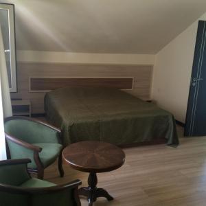 Hermon鲁斯图尔酒店的卧室配有一张床和一张桌子及椅子