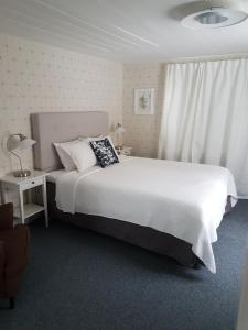 HedesundaHedesunda Bed & Breakfast的卧室设有一张白色大床和一扇窗户。