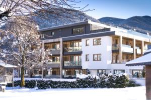 佩尔卡Alpin Hotel Sonnblick的白色的建筑,地面上积雪