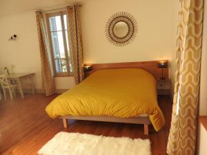 Pommiers-en-ForezDomaine de Laverchère的一间卧室配有黄色的床和镜子