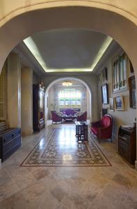 拉马萨达恩纳西姆住宿加早餐旅馆的客厅的拱门,配有红色椅子