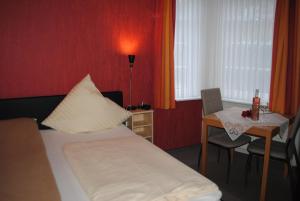 埃森斯加尔尼诺尔丁酒店的酒店客房配有一张床、一张桌子和一张桌子。