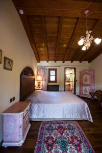 韦里亚科奇诺斯皮蒂精品旅馆的一间卧室设有一张带木制天花板的大床