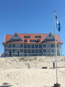 卡德赞德Cadzand Dream Beach, Pool and Wellness Apartment的沙滩上的酒店,沙滩上挂着旗帜