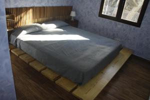 阿维拉Casa Rural Las Pegueras的一间卧室设有一张大床,铺有木地板