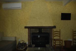 阿维拉Casa Rural Las Pegueras的客厅设有壁炉和电视。