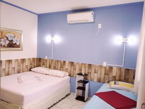卡舒埃拉保利斯塔Pousada Boa Vista的蓝色墙壁客房的两张床