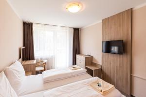 瓦赫河畔新梅斯托Bed & Breakfast Hotel Perla的酒店客房设有两张床和电视。