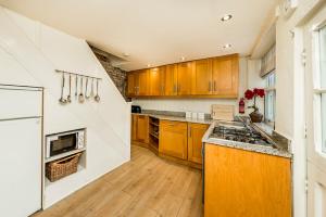 惠特比Old Kipper Cottage的厨房配有木制橱柜和炉灶烤箱。