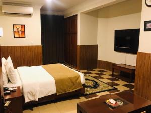 伊斯兰堡Hotel One Jinnah, Islamabad的一间酒店客房,配有一张床和一台电视