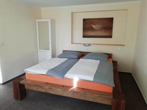 拉德博伊尔埃斯万斯道尔夫旅馆的一间卧室,卧室内配有一张木床