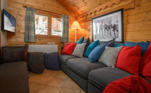 里蒙纽耶Chalet Ananas, Hameau des Marmottes的客厅配有带色彩缤纷枕头的灰色沙发