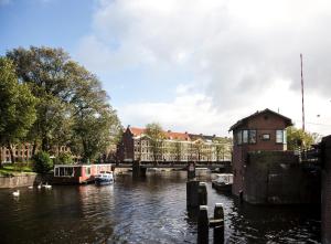 阿姆斯特丹SWEETS - Kattenslootbrug的一条河,上面有一座桥梁和船只
