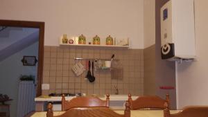 Albareto卡斯塔纳玛塔旅馆的厨房配有2把木椅和瓷砖墙