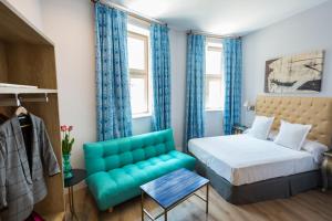 马拉加Casa de la Merced Suites的一间卧室配有一张床和一张蓝色的沙发