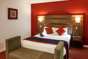 萨彻姆Mercure Newbury West Grange Hotel的配有一张床和一把椅子的酒店客房