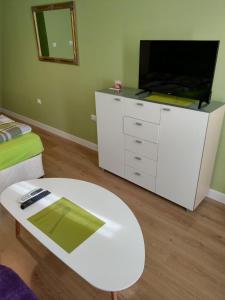 普列文Sasso-студио 3的客厅配有电视和白色桌子。