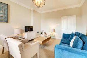 切尔滕纳姆Wolcote House的客厅配有蓝色的沙发和桌子