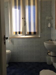 切齐纳码头Appartamento Acquamarina的一间带水槽和卫生间的浴室以及窗户。