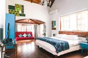 瓜亚基尔Iguanazu Bed & Breakfast的一间卧室配有一张大床和一张红色的沙发