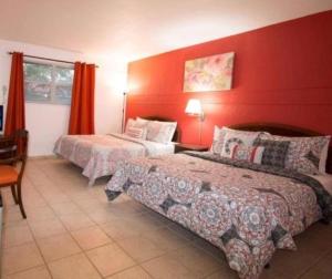 迈阿密加布勒斯旅馆的一间卧室设有两张床和红色的墙壁
