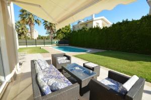 普罗塔拉斯Villa Daryah Sirina Bay的一个带桌椅的庭院和一个游泳池