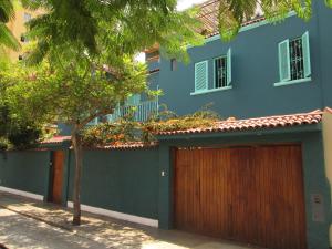 利马La Casona Azul的蓝色的建筑,有两个车库门,一棵树