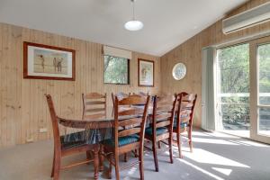 梅顿Casuarina的一间带木桌和椅子的用餐室