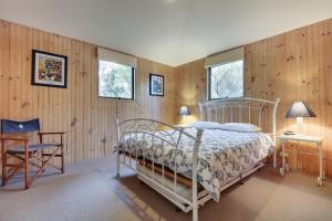 梅顿Casuarina的一间卧室配有一张床和一把椅子,还有两个窗户