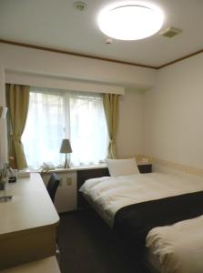 松山三番町酒店的酒店客房设有两张床和窗户。