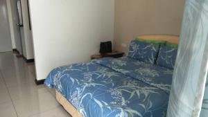 波德申DWharf Port Dickson (Private Condo)的一间卧室配有一张带蓝色和白色棉被的床