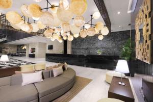 雅加达ASTON Priority Simatupang Hotel and Conference Center的客厅配有沙发和大吊灯。