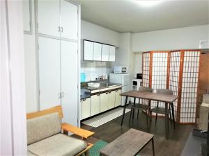 冈山Near Tram Apartment Okayama的一间带桌子的客厅和一间厨房