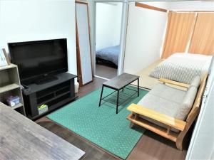 冈山Near Tram Apartment Okayama的客厅配有平面电视和沙发。