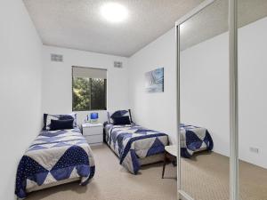 安特兰斯海豚苑5号公寓的一间卧室配有两张床和镜子