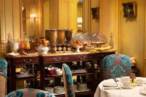 巴黎贝尔法斯特酒店的一间房间,配有一张桌子,上面放着盘子和碗
