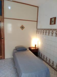 Tarrafal埃迪菲西奥魔幻酒店的一间卧室配有一张床和一张桌子上的台灯