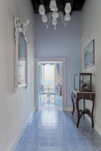 特罗佩阿Palazzo Mottola Tropea的蓝色的客房配有桌子和镜子