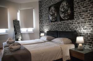 雅典The Athens Version Luxury Suites的一间卧室设有两张床和砖墙