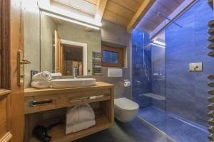齐勒河谷采尔Villa Haidacher Relax & Lifestyle Apartments的一间带水槽和玻璃淋浴的浴室