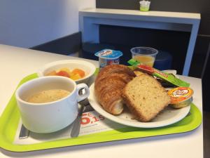 波城波城东宜必思快捷酒店的一杯咖啡和面包,一盘食物