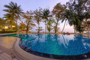 乔治市Mercure Penang Beach的一座棕榈树和海洋游泳池