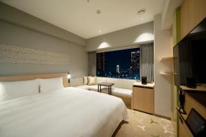 东京Miyako City Tokyo Takanawa的卧室设有一张白色大床和一扇窗户。