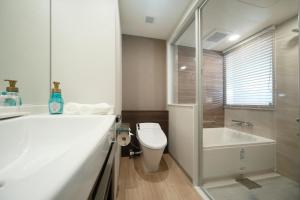 东京Miyako City Tokyo Takanawa的浴室配有卫生间、盥洗盆和浴缸。